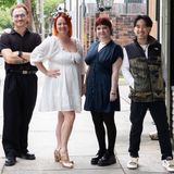 Sarah, Kevin, Adam, and Olivia walking and chatting on the sidewalk outside Good Vibes Barber Shop